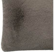 Gros plan d'un coussin décoratif doux en fausse fourrure gris-brun.
