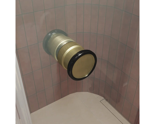 Un raccord de baignoire ou de douche en métal encastré dans le mur avec bague d étanchéité devant un mur carrelé.
