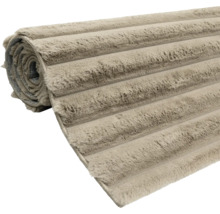 Ein aufgerollter Badezimmerteppich mit weicher Struktur und gerilltem Design.
