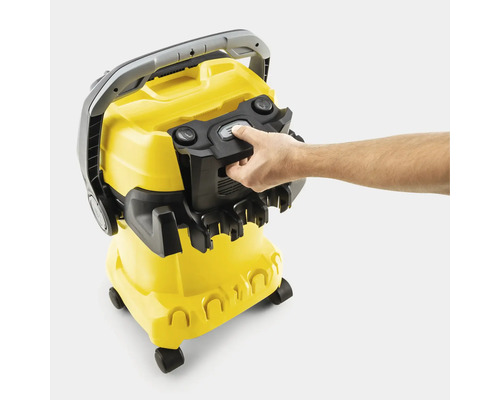 Main actionnant le mécanisme de verrouillage de l'aspirateur polyvalent Kärcher avec porte-accessoires.