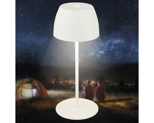 Moderne LED Akkuleuchte für den Außenbereich mit rundem Lampenschirm und stabilem Standfuß vor einer nächtlichen Campinglandschaft.