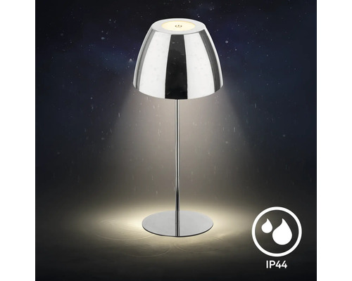 Lampe de table avec abat-jour brillant et indice de protection IP44 pour usage extérieur.