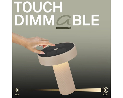 Eine Hand bedient eine dimmbare Tischleuchte mit Touchfunktion und Solarpanel auf der Oberseite.