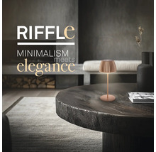 Moderne Tischleuchte im minimalistischen Design auf einem rustikalen Holztisch in einem elegant eingerichteten Wohnraum.