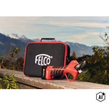 FELCO Akku Schere mit Transportkoffer vor einer Berglandschaft. (Image AI modified or generated)