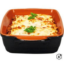 Eine rechteckige Auflaufform aus Keramik gefüllt mit frisch zubereiteten Cannelloni mit Käse überbacken und mit Petersilie garniert. (Image AI modified or generated)