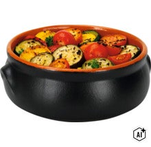 Eine runde schwarze Tontopf Schale gefüllt mit gegrilltem Gemüse wie Tomaten und Zucchini. (Image AI modified or generated)