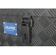 Detailansicht eines Alutec München Logos und eines Spannverschlusses an einer Transportbox mit Riffelblech Struktur