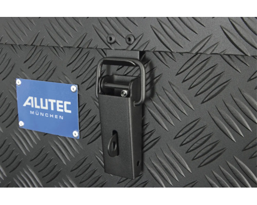 Detailansicht eines Alutec München Logos und eines Spannverschlusses an einer Transportbox mit Riffelblech Struktur