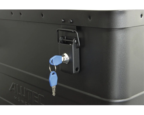 Detailansicht eines abschließbaren Spannverschlusses an einer Alutec Aluminiumbox mit eingestecktem Schlüssel.