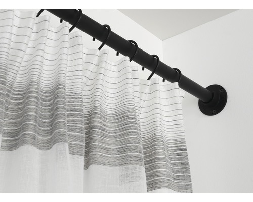 Tringle de rideau de douche avec rideau et anneaux sur un mur de salle de bain