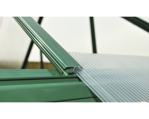 Vue détaillée du montage de la serre avec des plaques en plastique et un cadre métallique vert