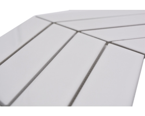 Gros plan de carreaux de céramique blancs rectangulaires disposés en chevrons.