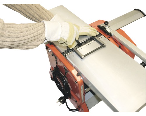 Hobelmaschine mit arbeitender Person in Handschuhen