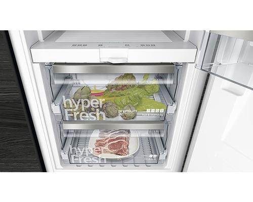 Innenansicht eines Kühlschranks mit Gemüse und Fleisch in Frischhaltefächern