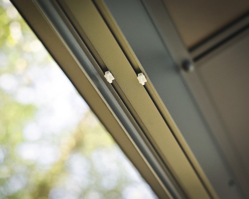 Vue détaillée d''une porte coulissante avec rail de guidage et rouleaux