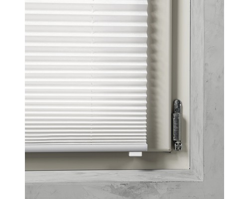 Vue détaillée d''un store plissé blanc sur une fenêtre