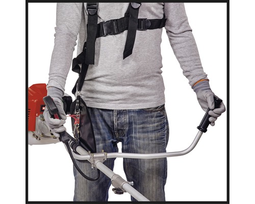 Eine Person, die eine Motorsense mit Tragegurt bedient.