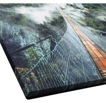 Nahaufnahme eines Kunstdrucks mit einer Hängebrücke über einen bewaldeten Canyon