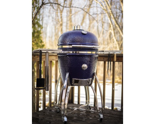 Barbecue en céramique avec couvercle et accessoires sur une terrasse
