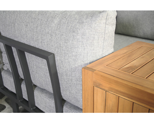 Detailansicht eines Lounge Sofas mit grauem Bezug und einem Holztisch