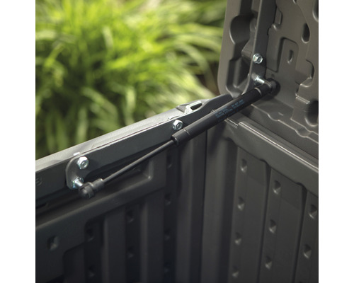 Detailansicht einer Gasdruckfeder an einer grauen Aufbewahrungsbox.