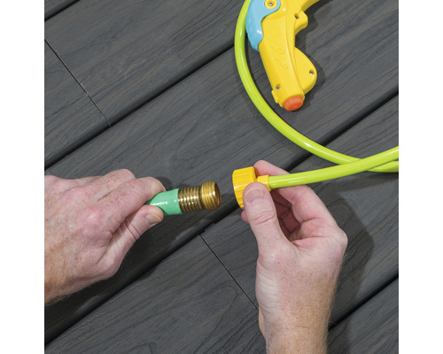 Deux mains connectent un raccord de tuyau d''arrosage à un tuyau d''arrosage