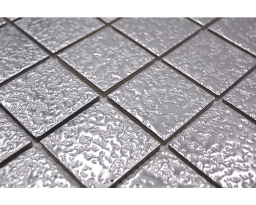 Gros plan de carreaux de mosaïque carrés argentés avec une surface inégale.