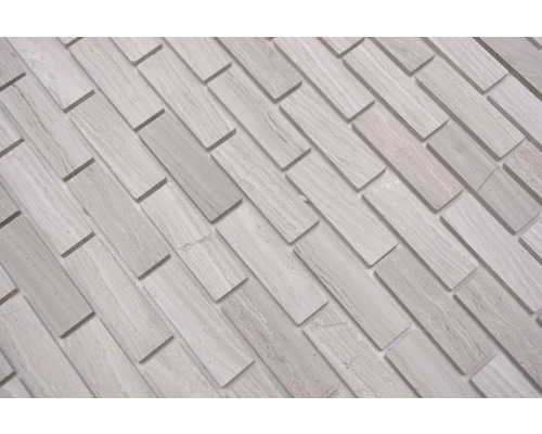 Carreaux muraux décoratifs en pierre naturelle claire, disposés de manière rectangulaire.