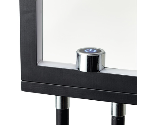 Detailansicht eines Spiegels mit einem runden, silberfarbenen Knopf mit einem blauen Power-Symbol.