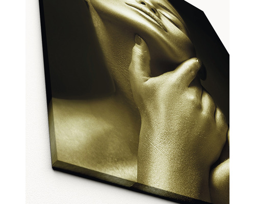 Nahaufnahme eines Goldfarbenen Kunstdrucks, der eine Frau zeigt, deren Hand ihr Gesicht berührt
