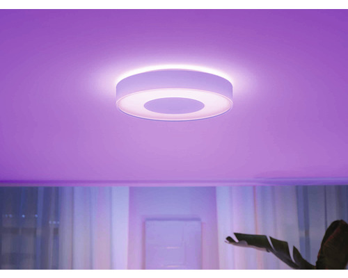 Plafonnier rond dans une pièce avec éclairage coloré.