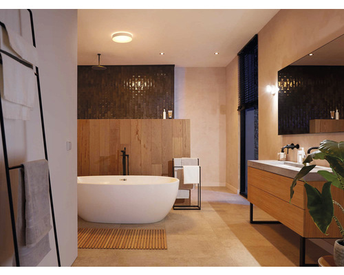 Badezimmer mit Badewanne, Waschtisch, Spiegel und Handtuchhalter für ein modernes Ambiente