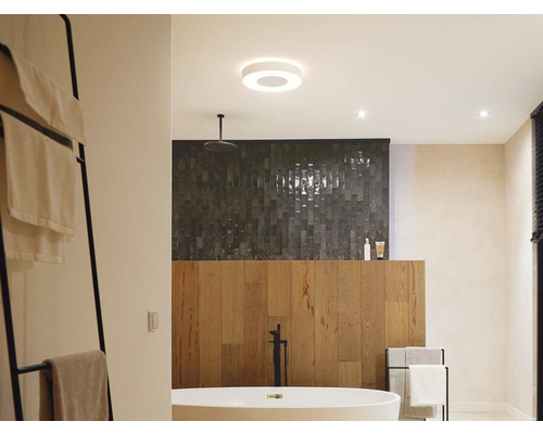 Badezimmer mit freistehender Badewanne, Handtuchhalter, Deckenleuchte und Dusche.