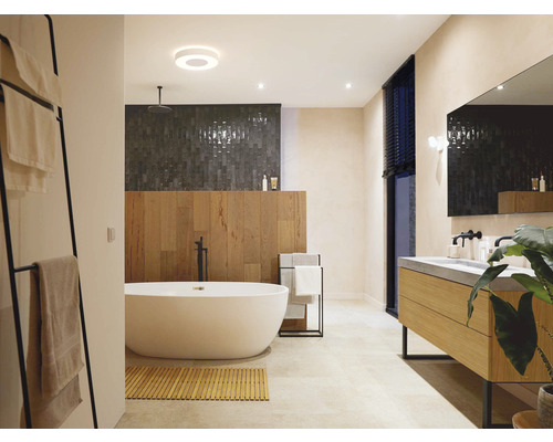 Helles Badezimmer mit freistehender Badewanne, Waschtisch und Handtuchhalter