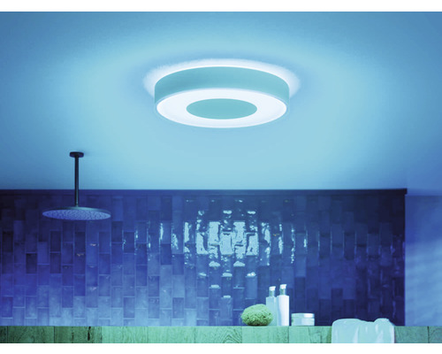 Badezimmer mit runder Deckenleuchte, Dusche und Kosmetikartikeln