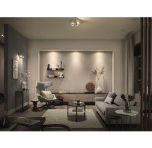 Wohnzimmer mit Sofa, Sessel und Beleuchtung für eine freundliche Atmosphäre