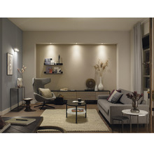 Wohnzimmer mit Sofa, Sessel, Couchtisch und Regalen für ein helles und organisiertes Ambiente.