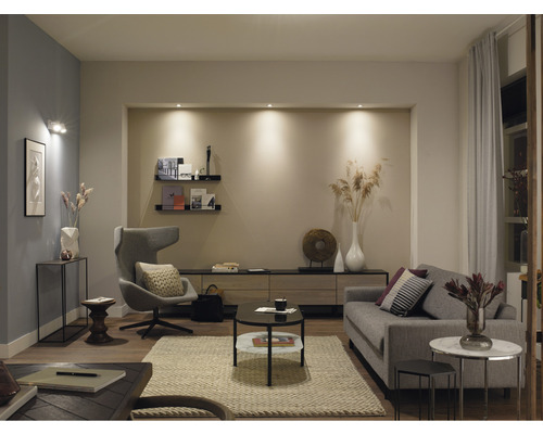 Wohnzimmer mit Sofa, Sessel und Beleuchtung