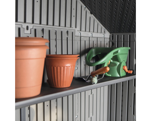 Étagère dans une remise de jardin avec des pots de fleurs et un épandeur