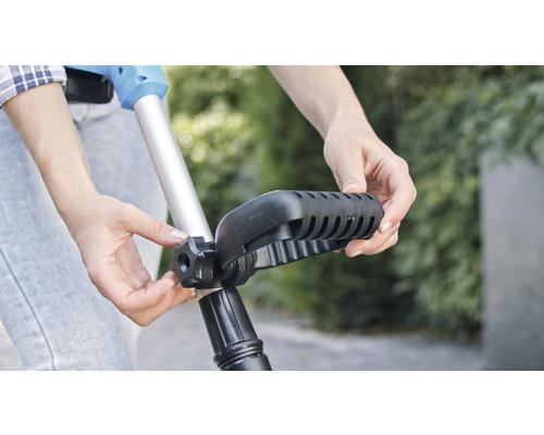 Person passt den Griff eines Rasentrimmers an