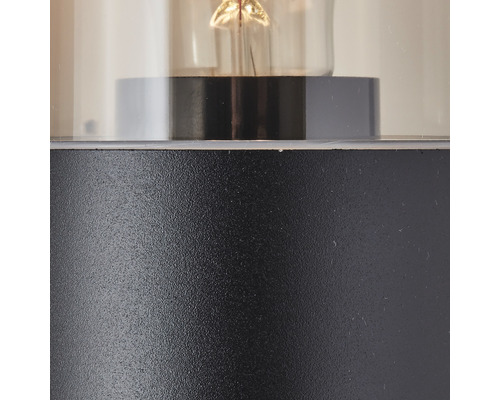 Detailaufnahme einer Leuchte mit klarem Glaszylinder und Metallsockel