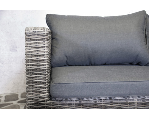 Detailansicht eines grauen Gartensofas aus Polyrattan mit Kissen.