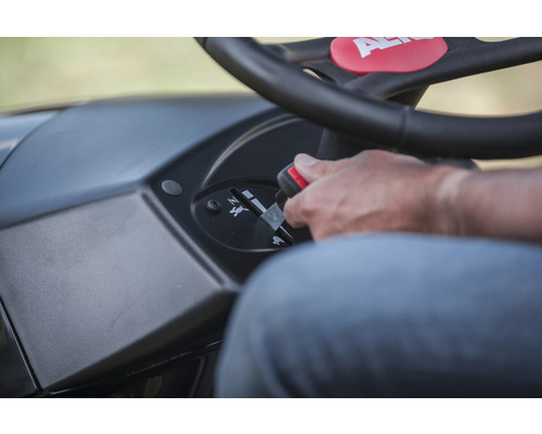 Gros plan du panneau de commande d''une tondeuse autoportée avec levier de vitesses et logo AL-KO sur le volant.
