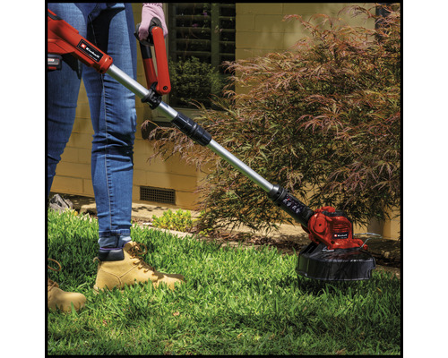 Une personne utilise un coupe-bordure Einhell dans le jardin.