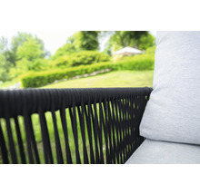 Gros plan d''un fauteuil de jardin avec un cadre tressé foncé et un rembourrage clair