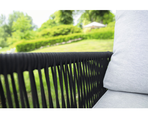 Gros plan d''un fauteuil de jardin avec un cadre tressé foncé et un rembourrage clair