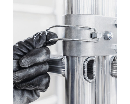 Gros plan d''une main gantée de travail fixant un dispositif de sécurité d''échelle