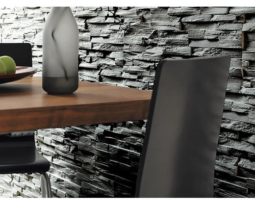 Nahaufnahme einer Wandverkleidung in Steinoptik hinter einem Esstisch mit Stühlen