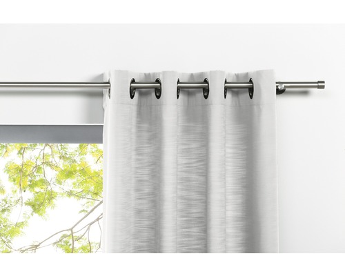 Rideau à œillets sur une tringle à rideaux devant une fenêtre